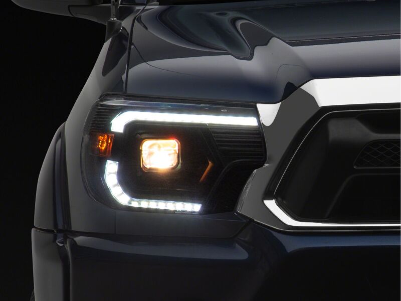 Raxiom 12-15 ToyotaTacoma Axial Series Switchback Projector Headlights- Black Housing- Clear Lens