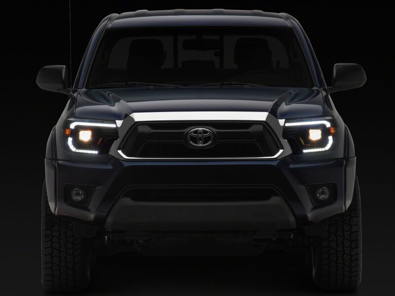 Raxiom 12-15 ToyotaTacoma Axial Series Switchback Projector Headlights- Black Housing- Clear Lens